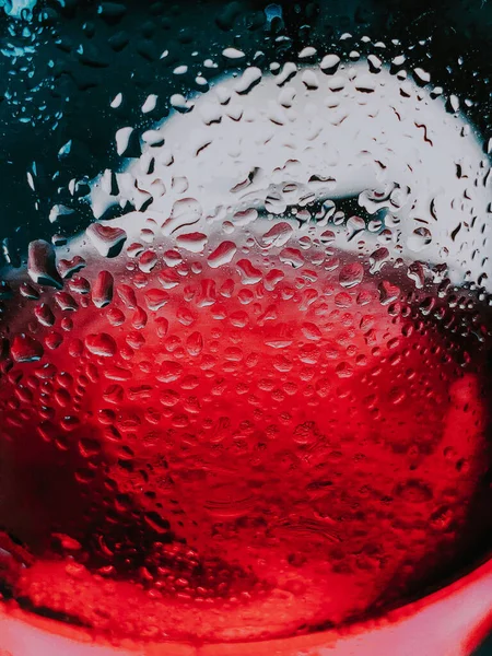 赤いガラス表面の上の水滴の垂直ショット — ストック写真