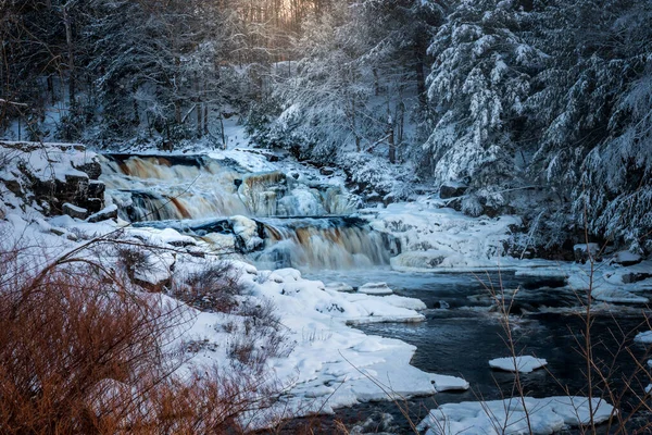 ニューヨーク州フランクリン郡ウェーバリーの雪に覆われた木々に囲まれたセント レジス滝 — ストック写真