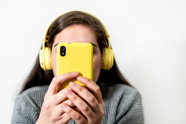 Uma Jovem Mulher Usando Fones Ouvido Amarelos Sem Fio Olhando — Fotografia de Stock