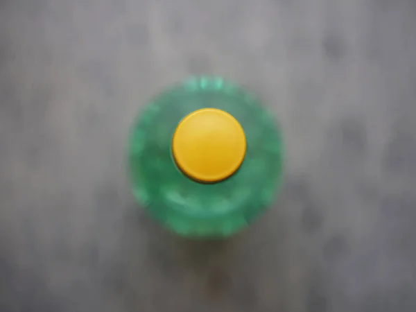Widok Góry Żółtego Wieczka Zielonej Plastikowej Butelki Środku Zamazanego Tła — Zdjęcie stockowe