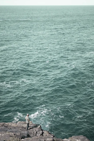 Plan Vertical Pêcheur Avec Une Canne Pêche Sur Une Côte — Photo