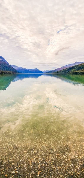 Sebuah Gambar Vertikal Dari Sebuah Danau Tenang Dikelilingi Oleh Pegunungan — Stok Foto