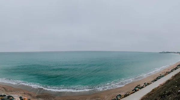 Een Zandkust Met Een Blauwe Zee Overdag — Stockfoto