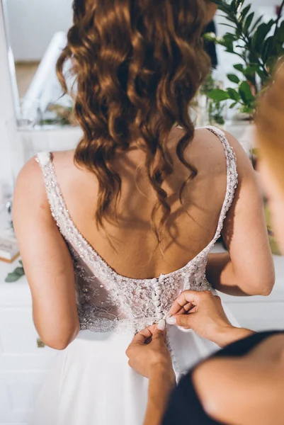 花嫁のドレスを固定する女性の手の垂直ショット — ストック写真