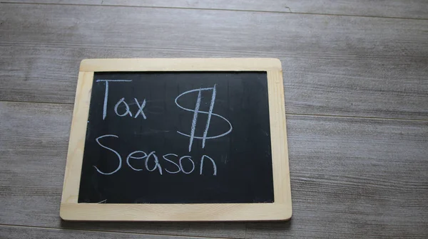 用粉笔写在上面的一个带有纳税季节的小黑板 — 图库照片