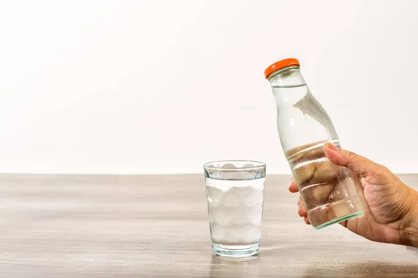 Female Hand Holding Water Bottle Glass Wooden Table — Stock Photo, Image