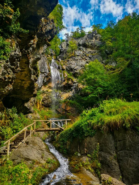 Niesamowite Ujęcie Wodospadu Widzianego Przez Drewniane Schody Skale Górskiej — Zdjęcie stockowe