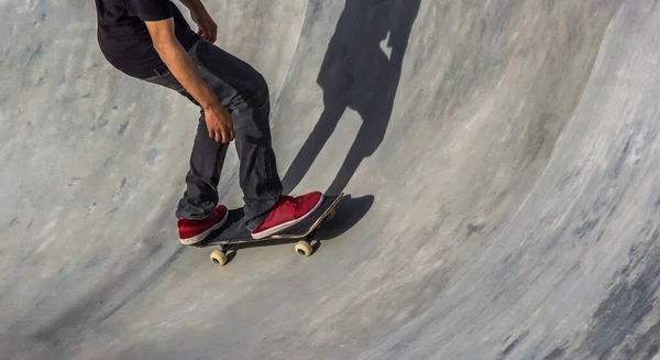 スケートボードの上に赤いバンのあるスケーターがスケートボードに乗っている — ストック写真