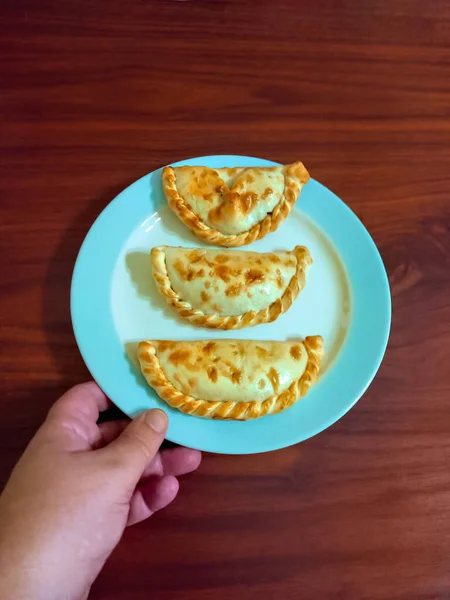 Tradycyjne Argentyńskie Empanadas Pieczone Talerzu Trzymanym Przez Rękę Ciasto Złożone — Zdjęcie stockowe