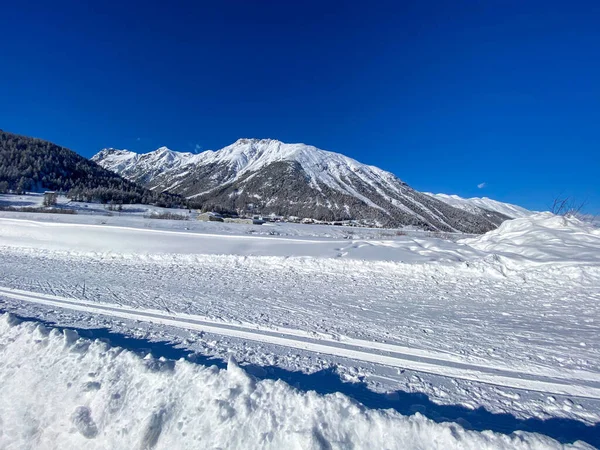 Vacker Utsikt Över Ett Snöfält Omgivet Kullar Blå Himmel Bakgrund — Stockfoto