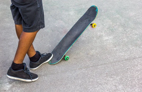 滑板上的一个年轻人踩着滑板的一端捡起滑板 — 图库照片
