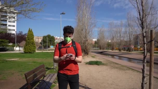 一名白种人男子 身穿红色衬衫 戴着面具 在公园打电话 慢动作 — 图库视频影像