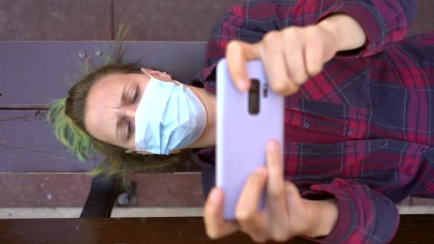 Spanish Woman Wearing Face Mask Lying Bench While Playing Video — стокове відео
