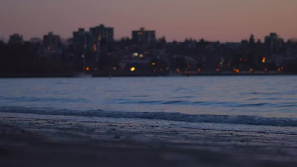Arka Planında Şehir Işıkları Olan Sakin Deniz Dalgalarının Manzarası — Stok video