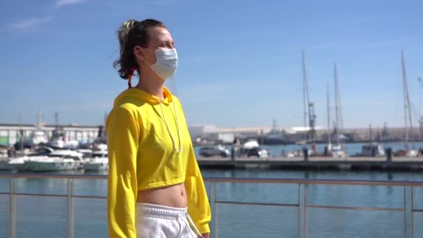 一个年轻的白种人女人 头戴黄色的庄稼顶盖 戴着面具 在港口享受她的一天 — 图库视频影像