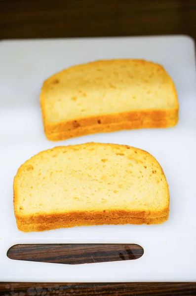 Vier Sneetjes Brood Liggend Een Witte Snijplank — Stockfoto