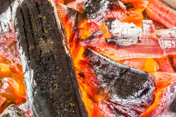 A high angle shots of logs and embers in a burning orange fire - cool fiery wallpaper