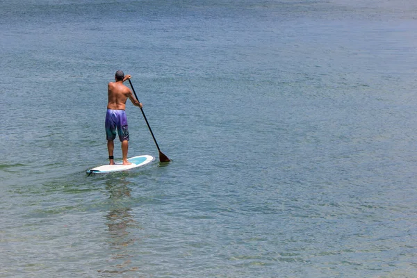 Ein Surfer Auf Einem Paddelbrett Schwimmt Durch Einen Ruhigen Ozean — Stockfoto