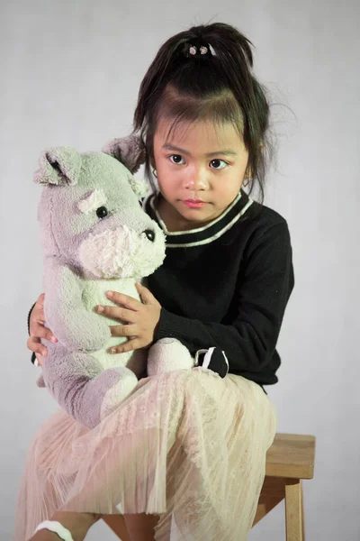 Güneydoğu Asyalı Sevimli Bir Kızın Oyuncağa Sarıldığı Dikey Bir Fotoğraf — Stok fotoğraf