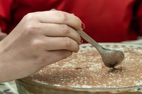 一个女人手里拿着勺子的特写镜头 在巧克力蛋糕上盘旋 — 图库照片