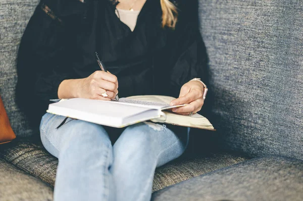 Eine Frau Sitzt Auf Einer Couch Und Schreibt Notizen Ihr — Stockfoto