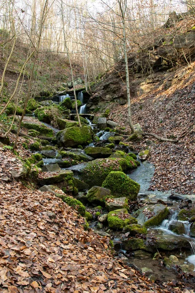 Vertikální Záběr Malého Vodopádu Který Vznáší Nad Mechem Porostlými Skalami — Stock fotografie