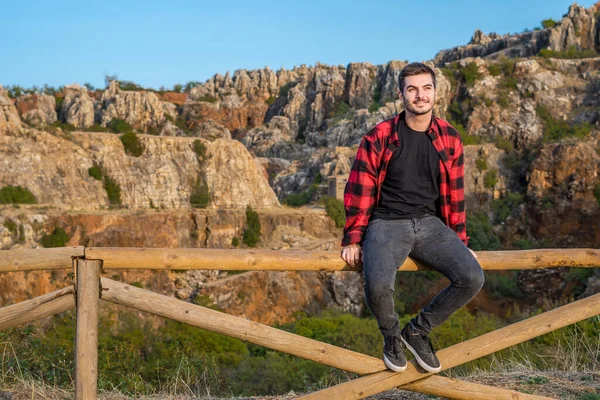 Young Caucasian Man Spain Sitting Wooden Fence Admiring Mountain View — стоковое фото