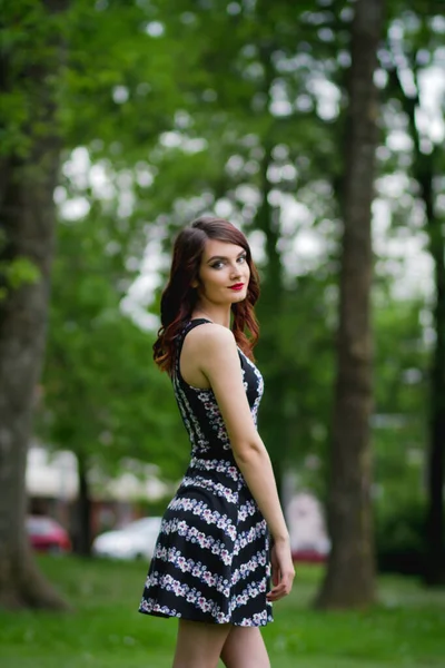 Tiro Vertical Uma Jovem Morena Feminina Vestido Floral Posando Parque — Fotografia de Stock