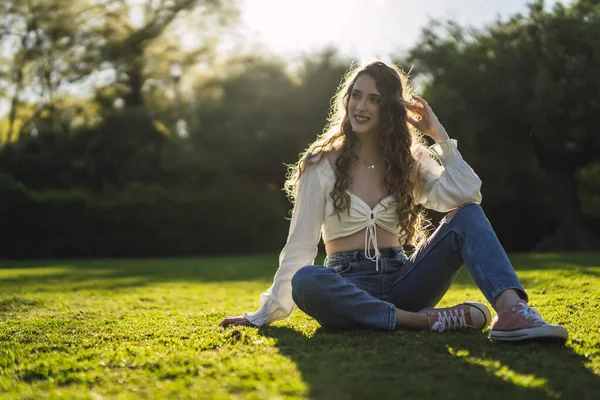 stock image A shallow focus shot of a beautiful Spanish Caucasian woman with curly hair, sitting on the grass