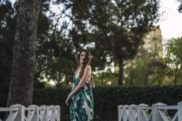 緑のドレスを着た公園を楽しそうに歩いているスペイン出身の白人女性 — ストック写真