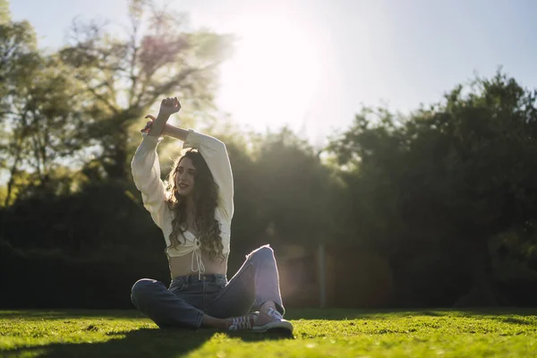 Beautiful Caucasian Woman Spain White Top Jeans Sitting Grass Stretching — стоковое фото