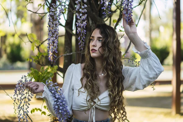 Güzel Bir Spanyol Beyaz Kadının Wisteria Çiçeklerinin Yanında Poz Verirken — Stok fotoğraf