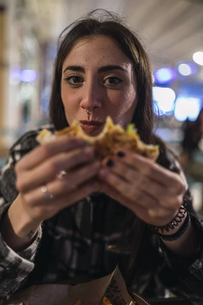 Foco Superficial Uma Jovem Morena Com Piercing Nariz Comendo Hambúrguer — Fotografia de Stock