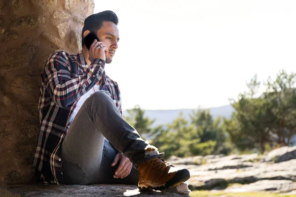 Mladý Španělský Muž Který Odpočívá Kamenné Zdi Mluví Mobilu — Stock fotografie
