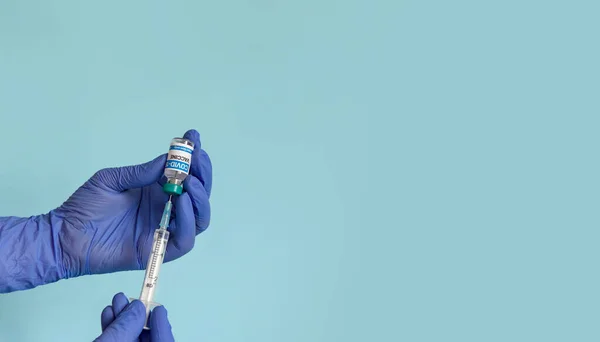 의사들 주사기와 있습니다 파란색 배경에 백신을 간호사의 포커스 이미지 — 스톡 사진