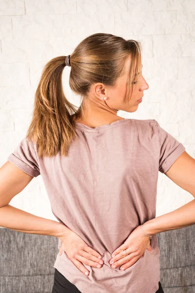 Lower Back Pain Blonde European Woman Pigtail Holding Hands Her — стоковое фото