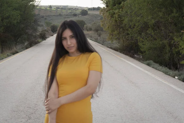 セクシーなラティーナ女性を身に着けていますタイト黄色のドレスとポージング上の道路 — ストック写真