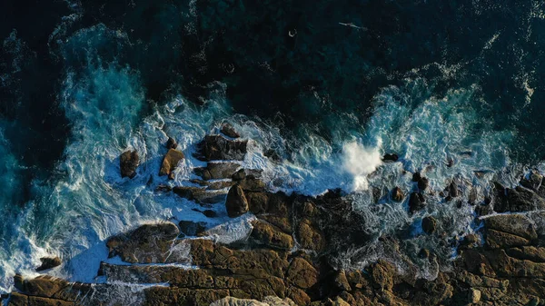 Een Luchtfoto Van Golvende Oceaan Die Rotsachtige Kliffen Aan Kust — Stockfoto