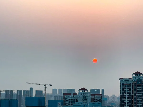 日落时 在蓝色城市的屋顶上 一轮橙色的满月映入眼帘 令人惊叹 — 图库照片