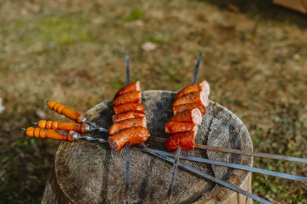 Closeup Sausages Skewers Placed Wooden Bark Outdoors — Stock Photo, Image