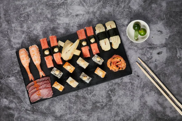Överblick Över Läcker Sushi Serveras Svart Träplatta Med Ätpinnar — Stockfoto