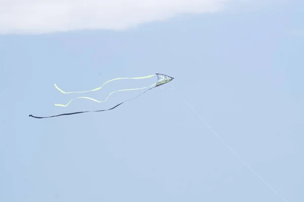一只蓝绿色的风筝在天空的云彩下飞翔 — 图库照片