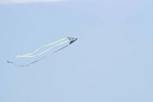 Синий Зеленый Маленький Воздушный Змей Летящий Против Мягкого Голубого Неба — стоковое фото