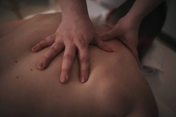 Młody Mężczyzna Korzystający Relaksujący Masaż Wykonywane Przez Profesjonalnego Masażystę Salonie — Zdjęcie stockowe