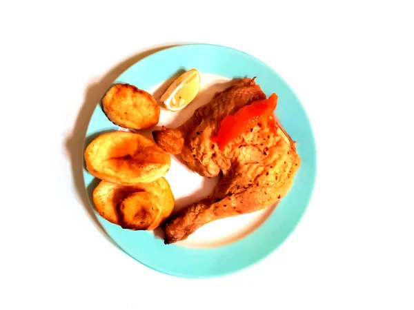 白い背景のプレート上に伝統的な調理鶏の足とローストスペインのジャガイモのオーバーヘッドショット — ストック写真