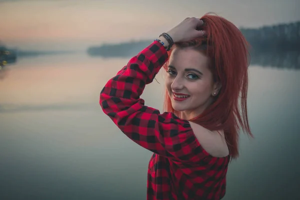 一位年轻迷人的白种人女子 穿着红衫 日落时在海边摆姿势 — 图库照片