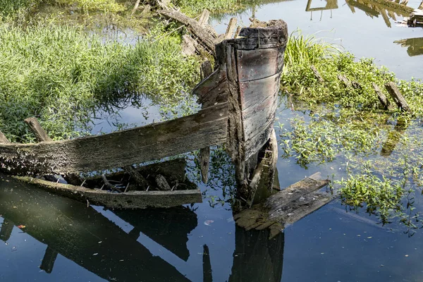 Barco Madera Roto Agua Tranquila Reflectante Rodeado Plantas Verdes — Foto de Stock
