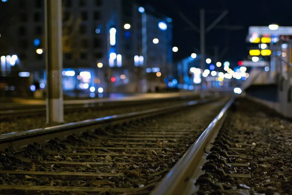 Een Selectieve Focus Shot Van Spoorrails Met Stadsverlichting Nachts Achtergrond — Stockfoto