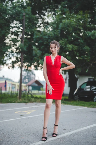 Egy Csinos Fiatal Kaukázusi Elegáns Piros Ruhában Pózol Egy Parkban — Stock Fotó