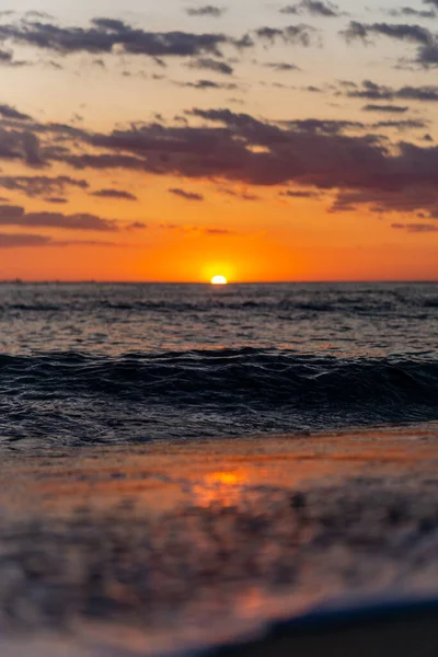 黄金の夕日の空の下で穏やかな海の垂直ショット — ストック写真